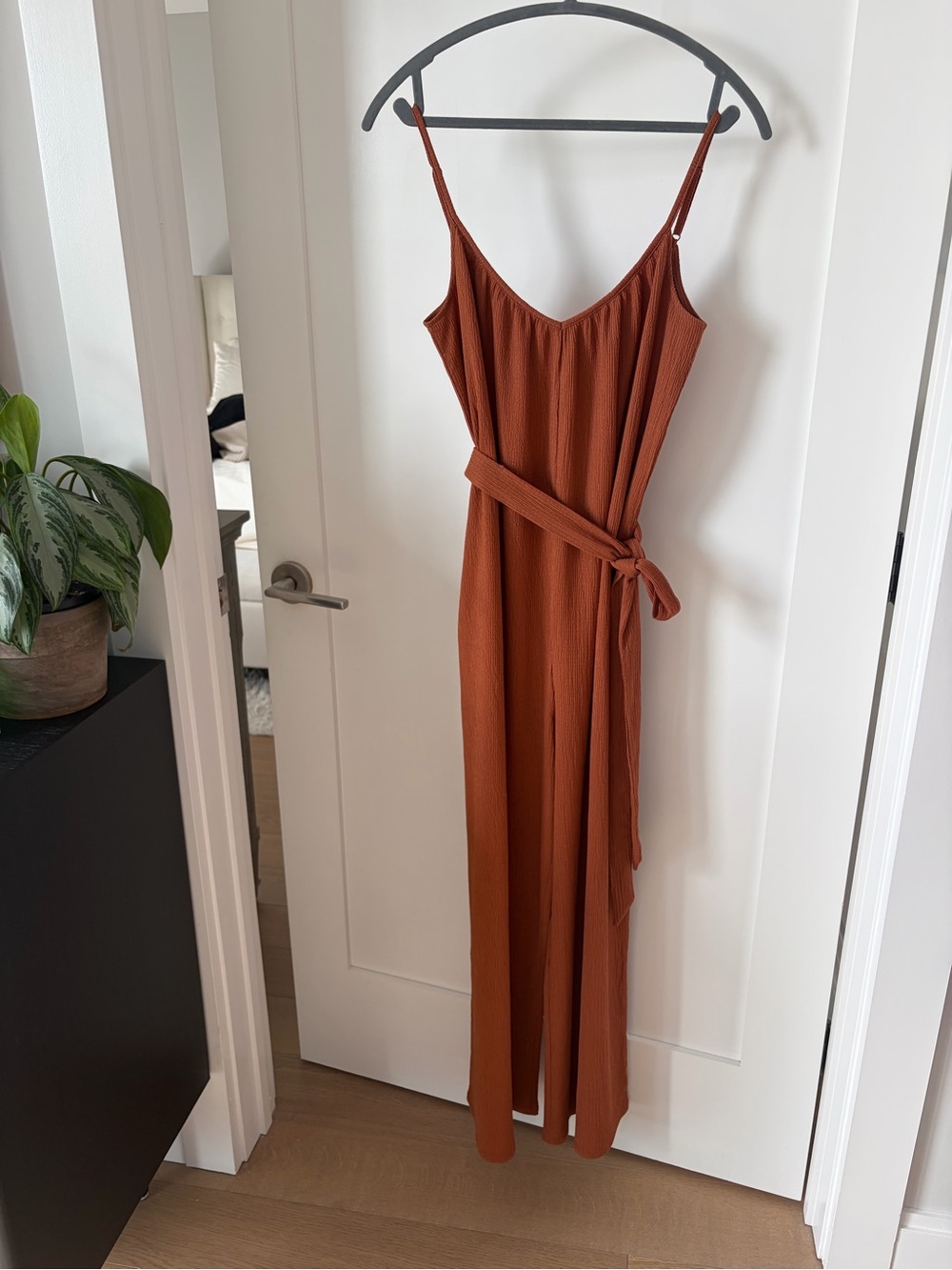 Rust colored jumpsuit with tie waist and pockets
